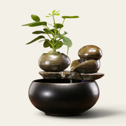 Fontaine céramique noir design avec cascade d'eau et plante verte pour une décoration zen
