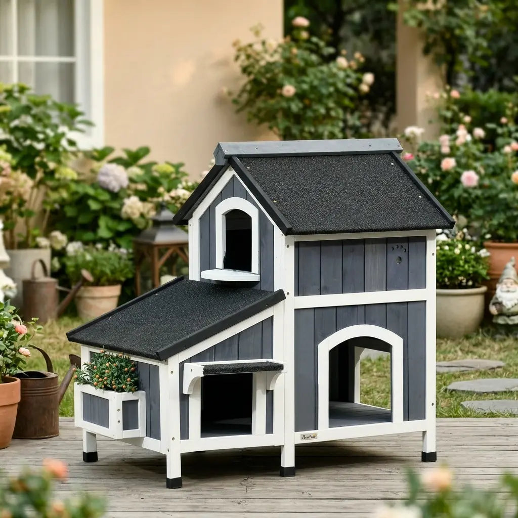 Grande maison pour chat extérieur installée dans un jardin avec structure en bois résistante aux intempéries.