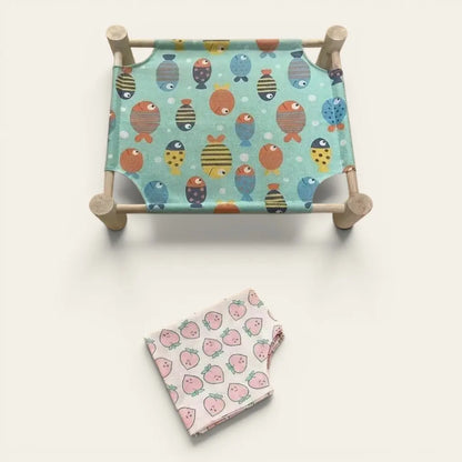 Hamac chat sur pied confortable avec toile motif fraises et structure en bois stable pour chat d’appartement.