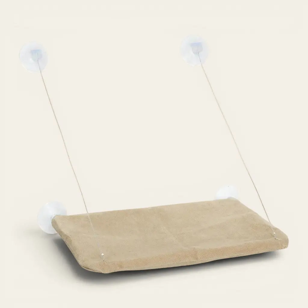 Hamac pour chat ventouse beige suspendu sur vitre permettant à votre félin de se détendre en hauteur.
