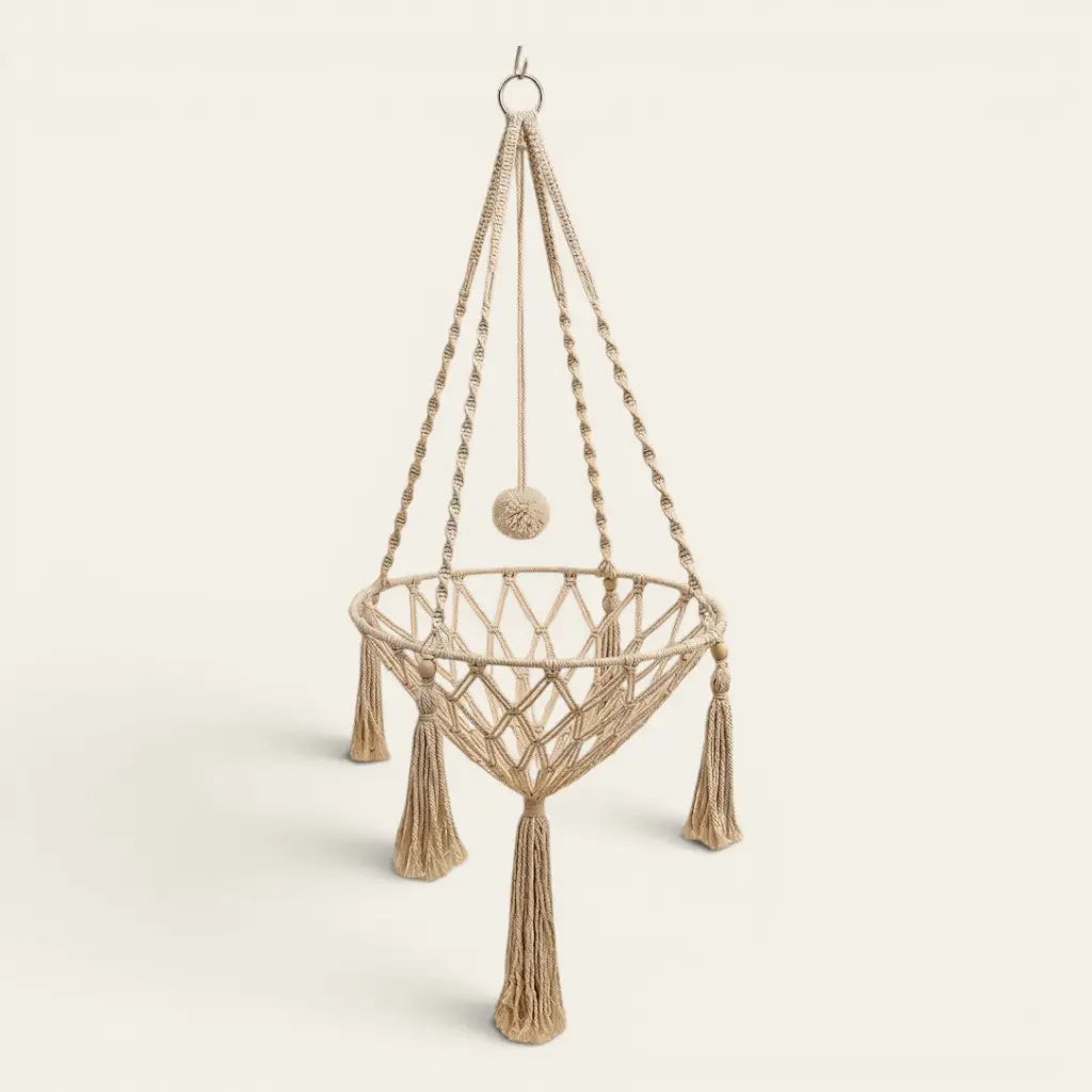 Panier pour chat suspendu en macramé avec pompons décoratifs offrant un couchage aérien et élégant pour chat d’intérieur.
