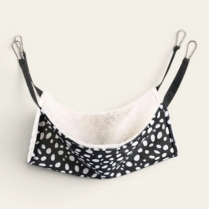Transat pour chat suspendu à pois noir et blanc avec intérieur moelleux offrant un couchage confortable.